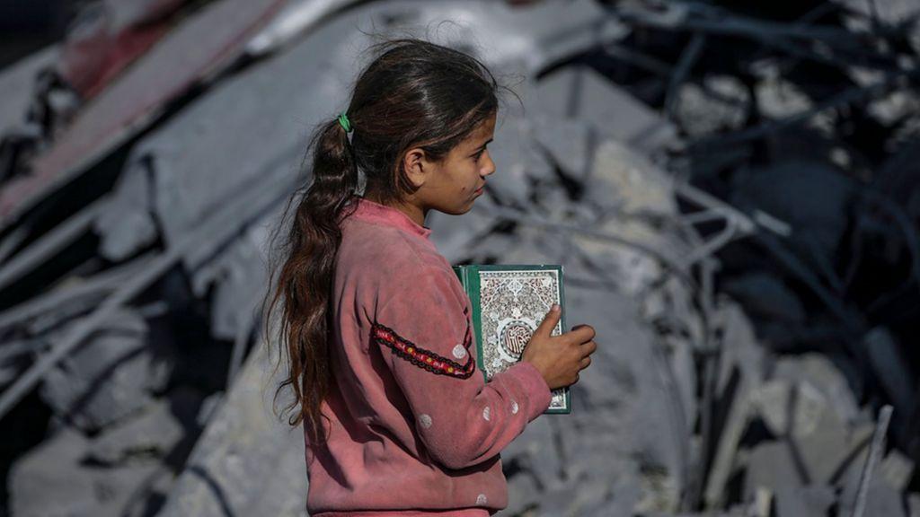 Una niña con un libro del Corán