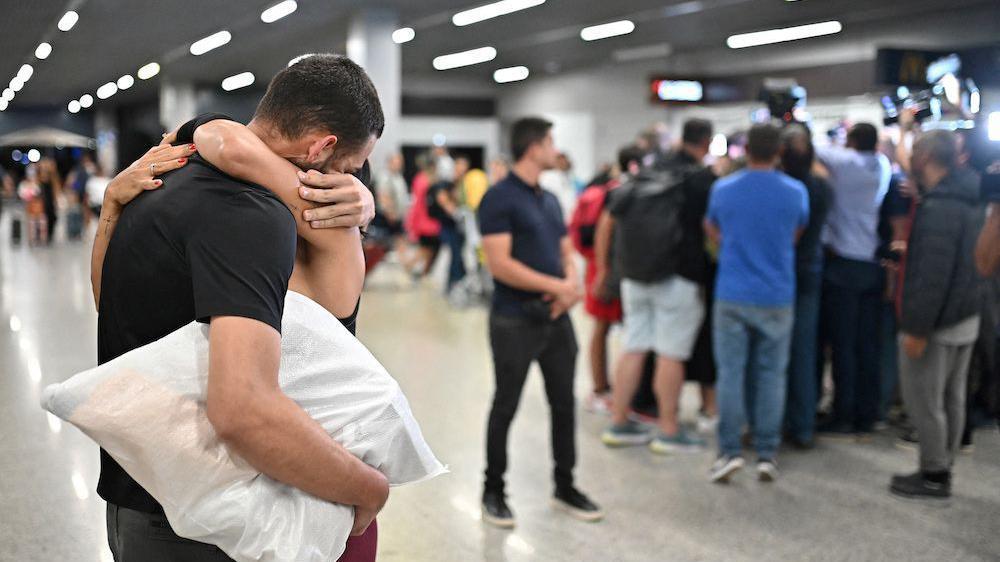 O homem abraça a mulher no aeroporto de Confins em 26 de janeiro de 2024