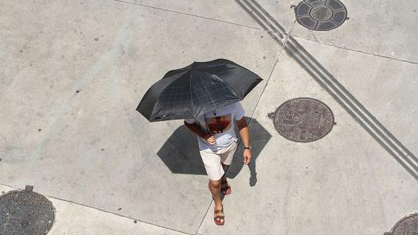 Homem andando com guarda -chuva