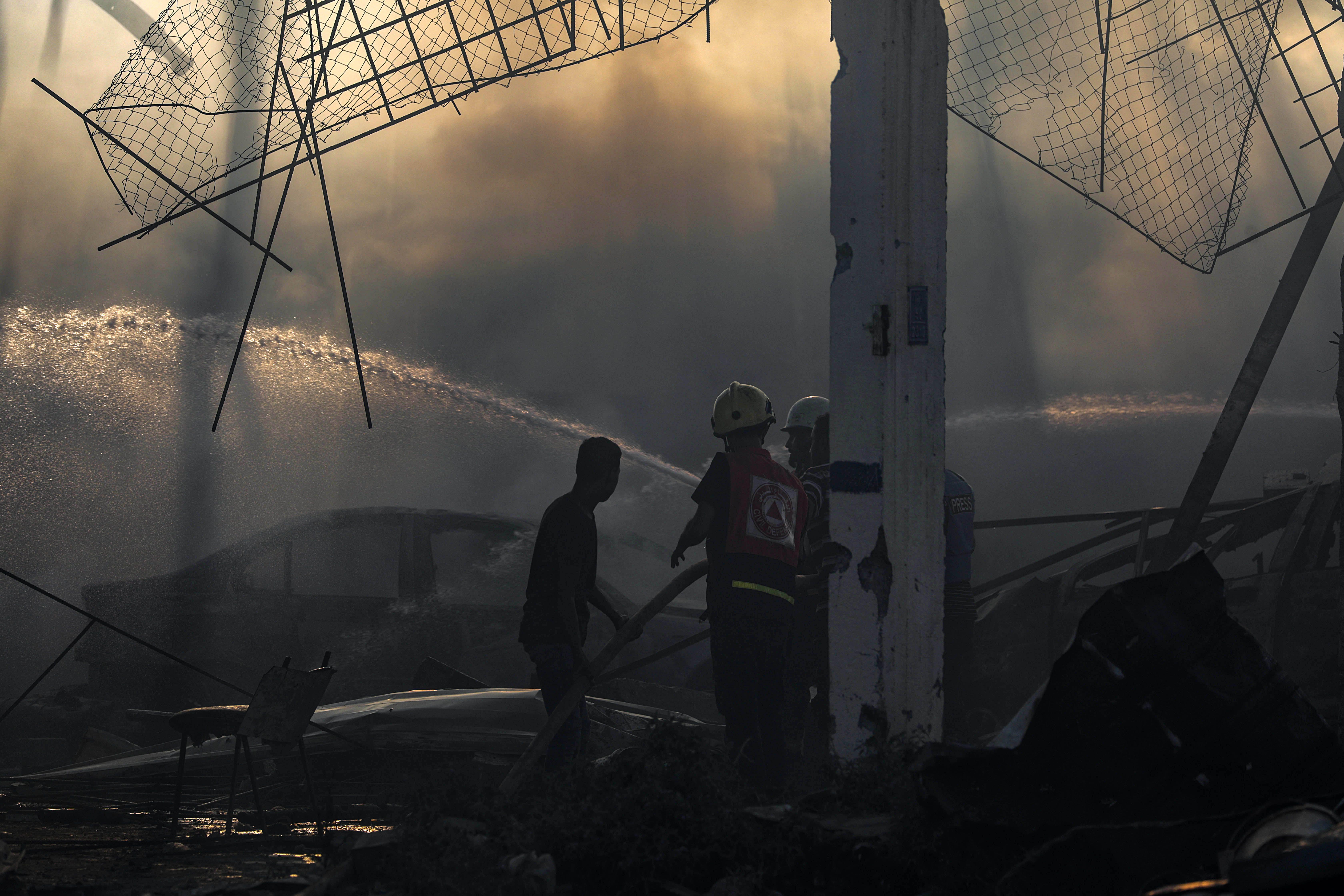 Palestinos inspecionam os escombros de um prédio destruído após um ataque aéreo israelense no bairro de Al-Zawaida, no centro de Gaza, em 19 de julho de 2024