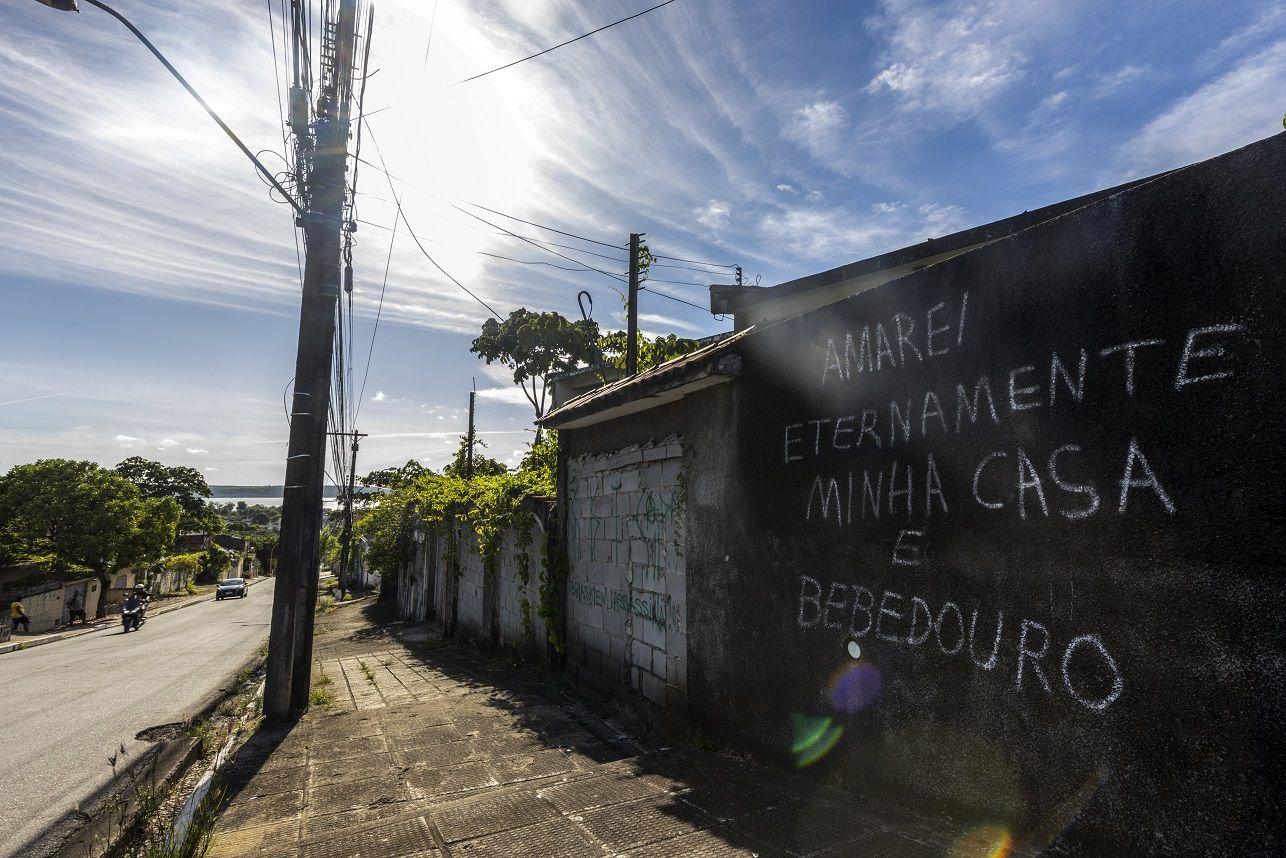 Muro preto com pichação: 'Amarei eternamente minha casa e Bebedouro'