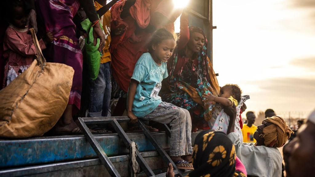 niños y mujeres refugiados que escaparon de sudán en un camión 