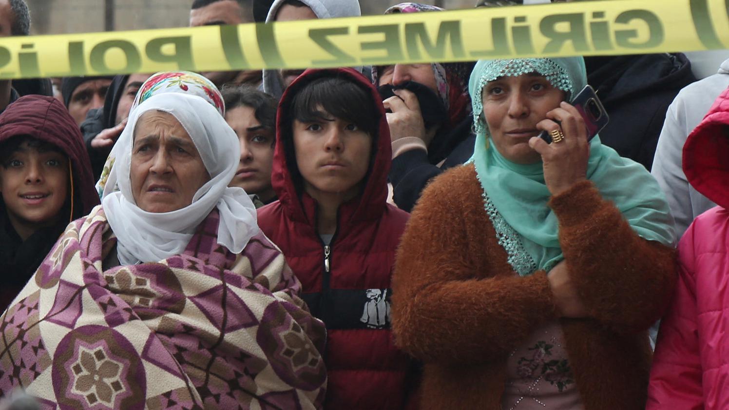 People watch as rescue operations take place on a site after an earthquake in Diyarbakir, Turkey on 6 February 6 2023