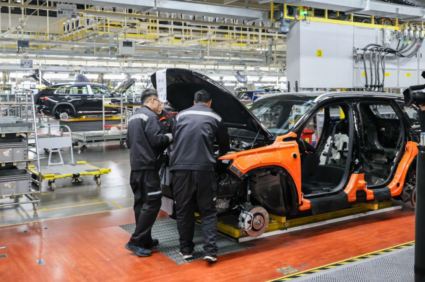 Funcionários trabalham na linha de montagem de veículos elétricos inteligentes (EV) na base de fabricação de automóveis da Geely em 12 de dezembro de 2024 em Xi'an, província de Shaanxi, China.