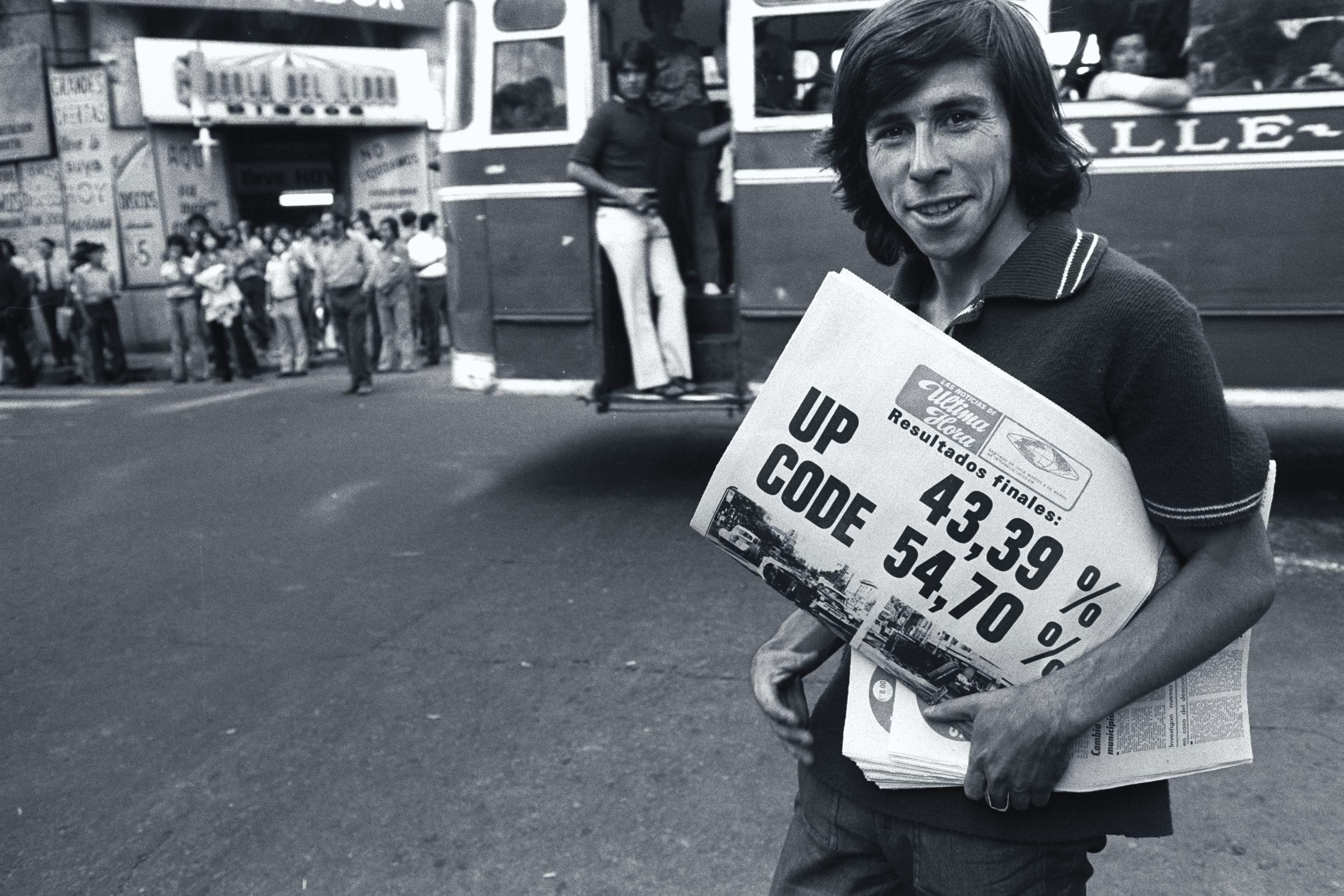 Un hombre vende diarios con los resultados de las elecciones parlamentarias de 1973 en Chile.