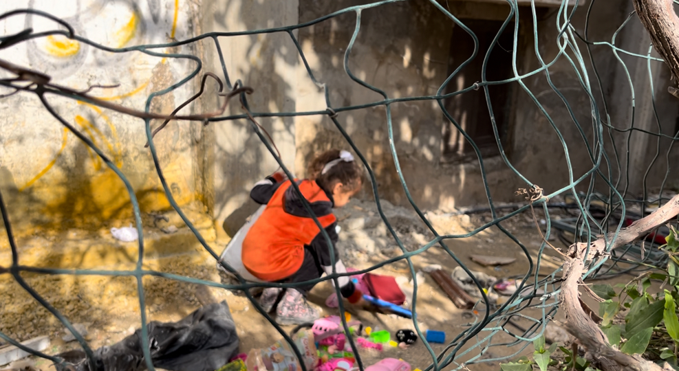 طفلة فلسطينية تجمع العابها التي تناثرت بعد ان دمرت القوات الإسرائيلية منزل عائلتها 