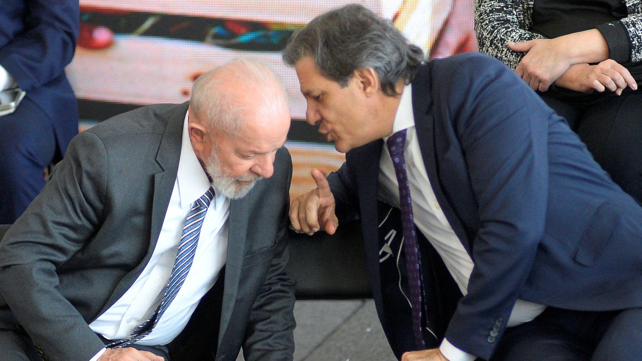 O ministro da Fazenda, Fernando Haddad, falando ao pé do ouvido do presidente Luiz Inácio Lula da Silva durante evento no Palácio do Planalto em julho