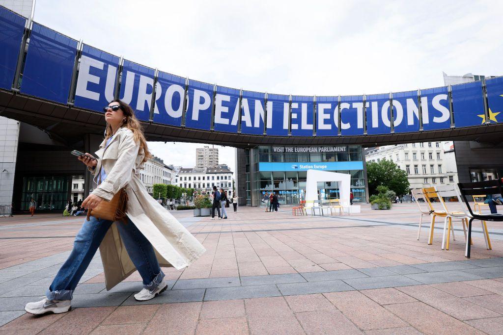 Una mujer pasa delante de un cartel de las elecciones europeas.