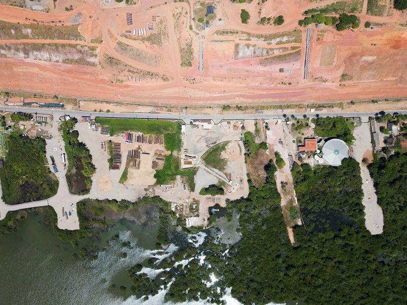 Foto aérea mostra casas, lago e mata