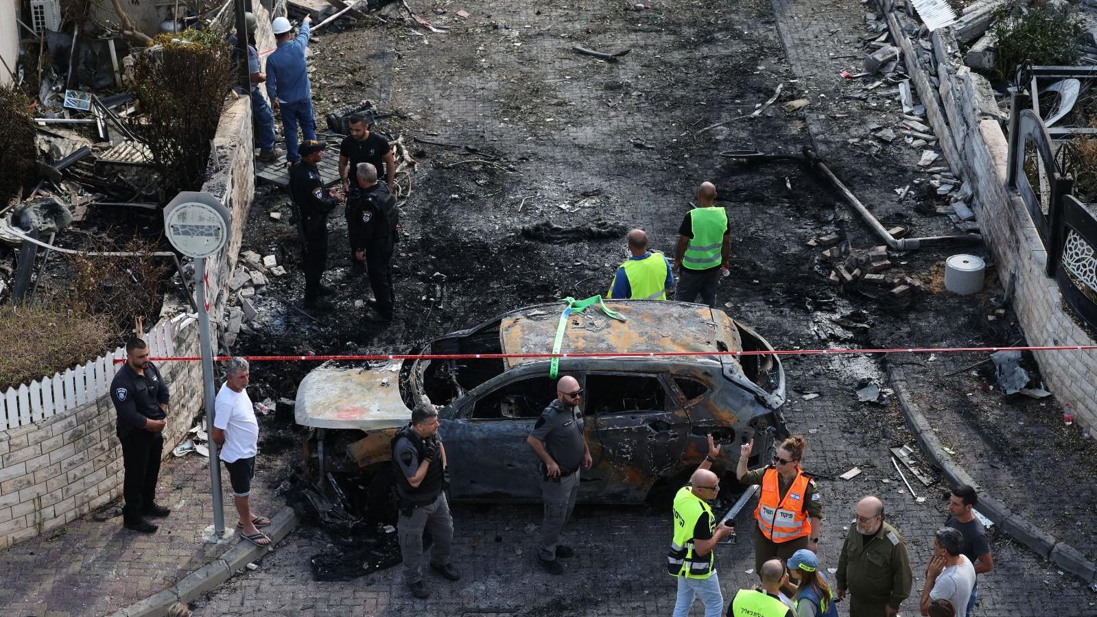 Equipes de emergência israelenses trabalham no local de um ataque de míssil em um bairro residencial em Kiryat Bialik, norte de Israel, 22 de setembro de 2024