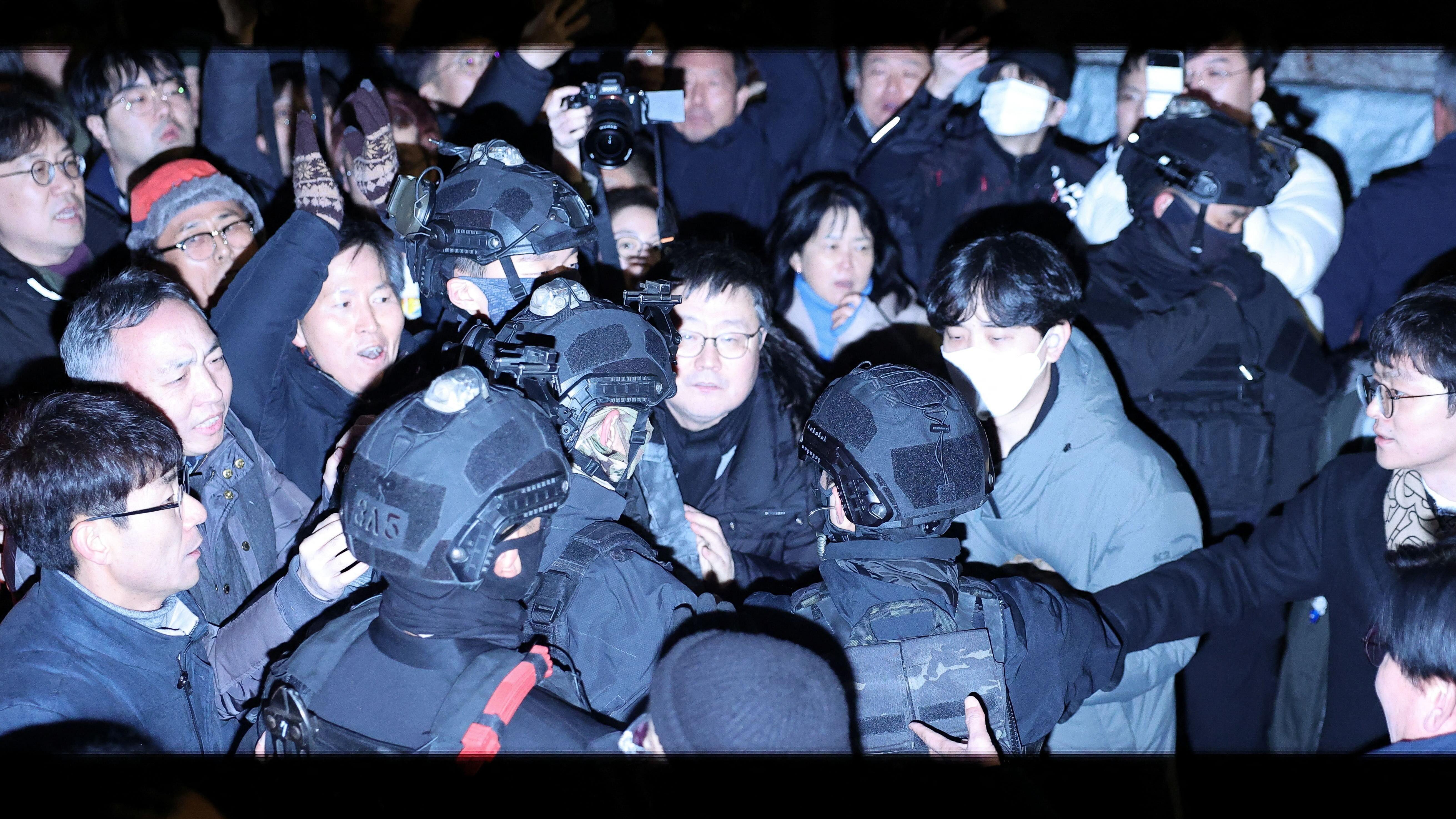 Miembros del ejército se abren paso entre la multitud frente a la Asamblea Nacional en Seúl en las primeras horas del 4 de diciembre después de que el presidente surcoreano, Yoon Suk-yeol, declarara la ley marcial.