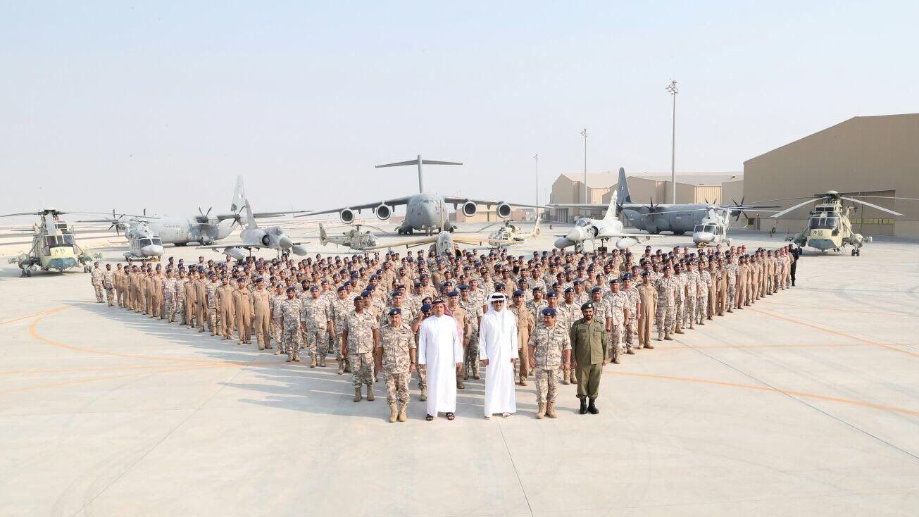 صورة لأمير قطر تميم بن حمد آل ثاني، يقف رفقة جنود، خلال زيارته قاعدة العديد الجوية في قطر سنة 2017.