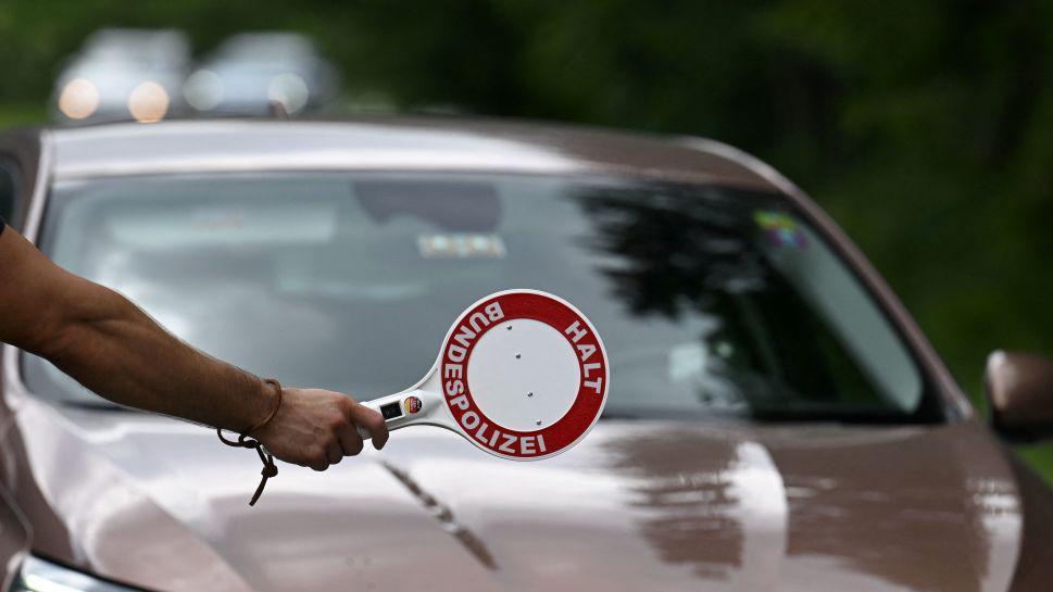 Un policía alemán detiene a un carro en la frontera.