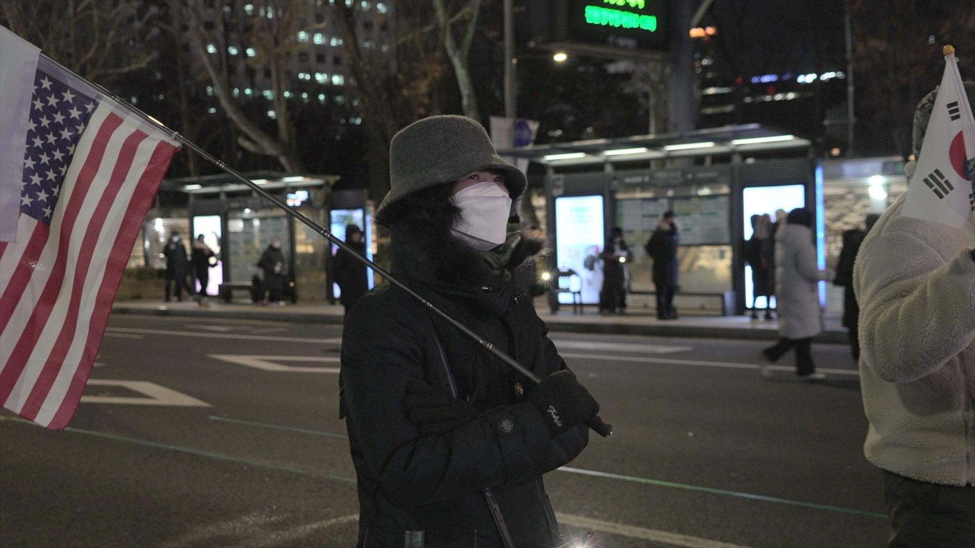 태극기와 성조기를 들고 윤석열 대통령 탄핵 반대 집회에 참석한 한 여성