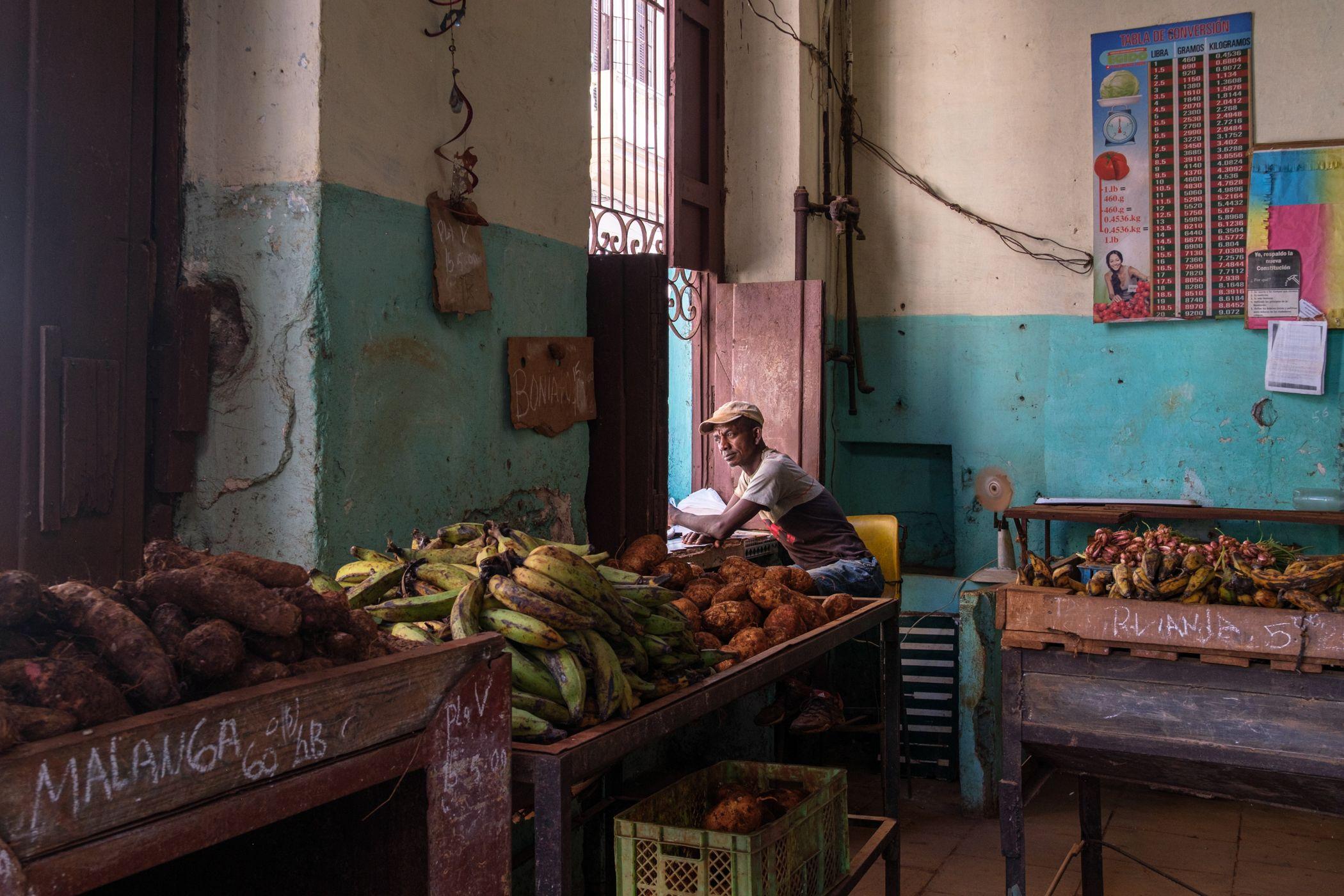 Un trabajador mira por la ventana de una tienda de alimentos en La Habana.