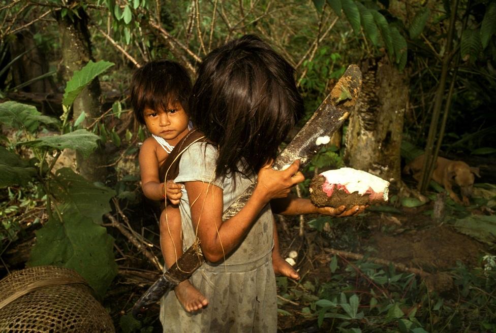 Una niña carga a un niño más pequeño en la espalda