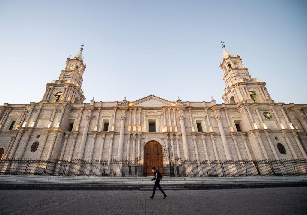 Una persona camina frente a uno de los edificios monumentales de la Plaza de Armas de Lima