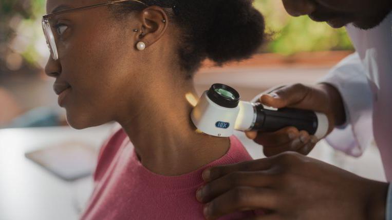 Médico checando pele de paciente