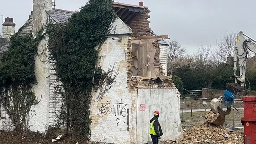 Foto mostra casa sendo demolida