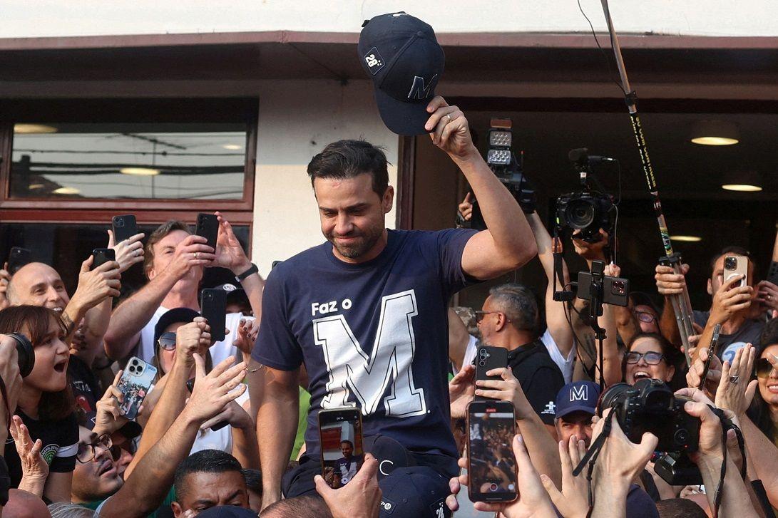 Marçal rodeado por apoiadores, que gritam e tiram foto