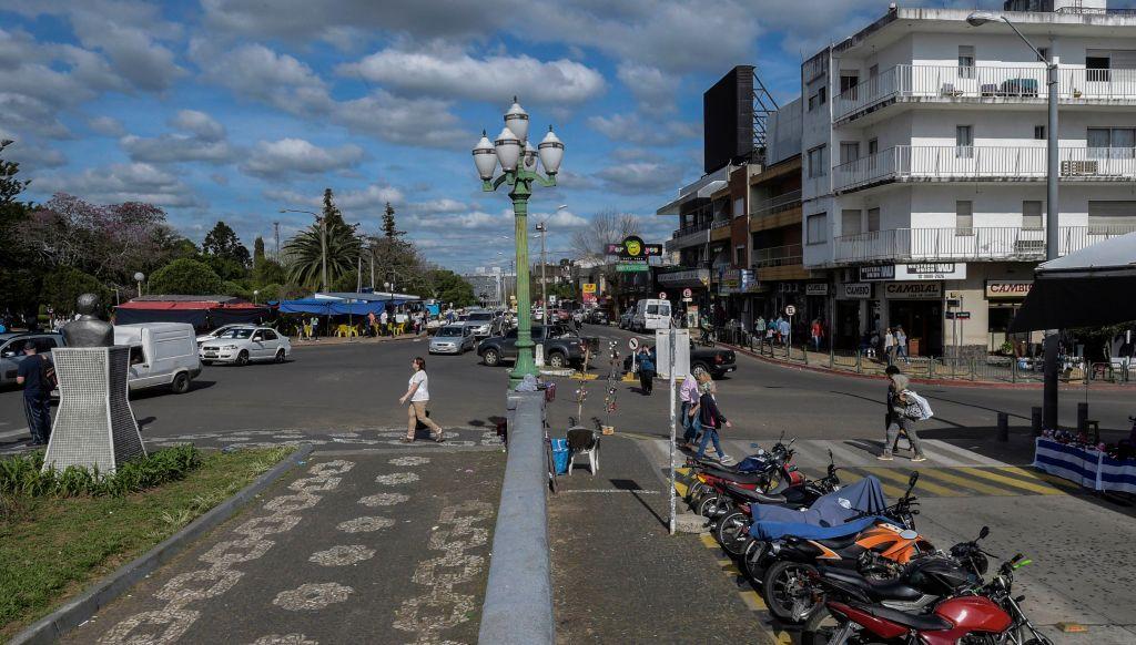 Rua de uma cidade, com um muro no meio dividindo duas cidades 