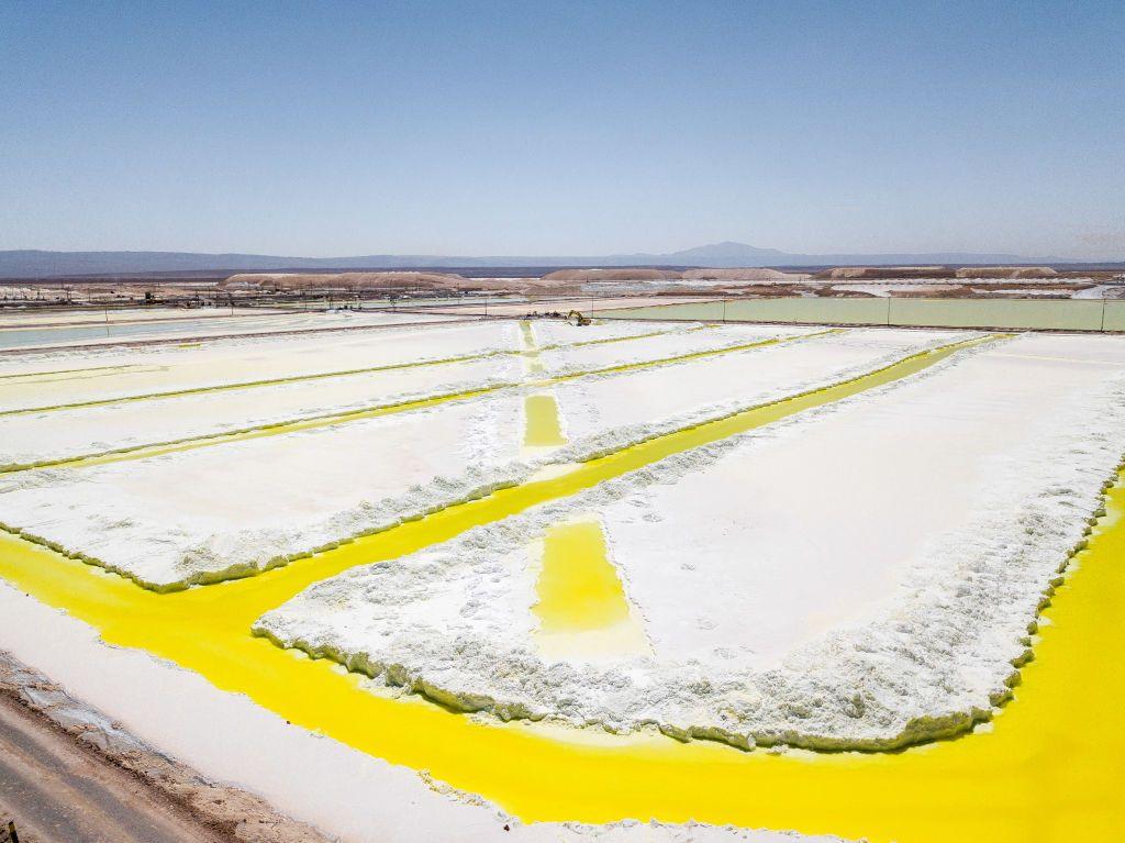 Piscinas amareladas em uma área plana e desértica 