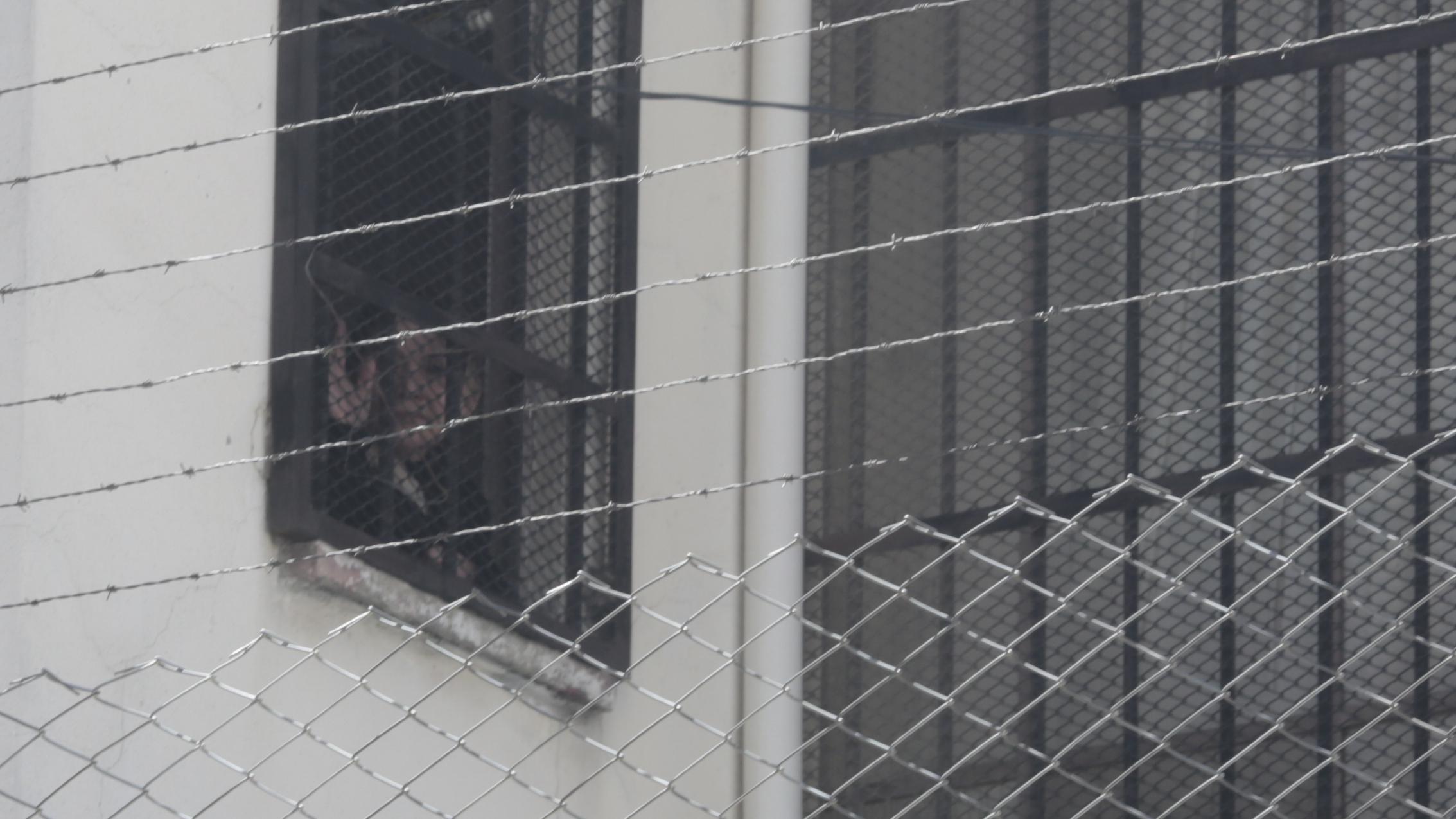 Jeanine Áñez vista de janela da prisão, olhando para fora