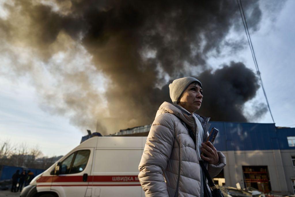 Mujer en Kyiv frente a columna de humo
