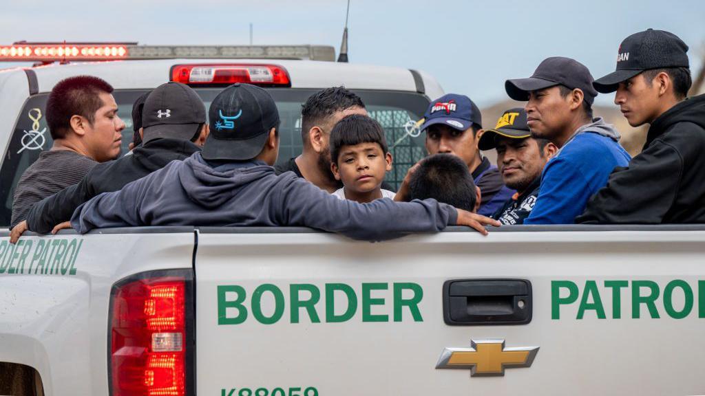 Una camioneta de la patrulla fronteriza lleva a varios migrantes. 