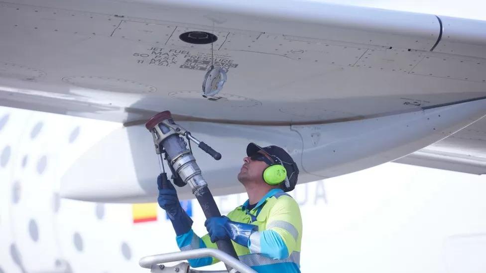 Pessoa abastecendo um avião com combustível