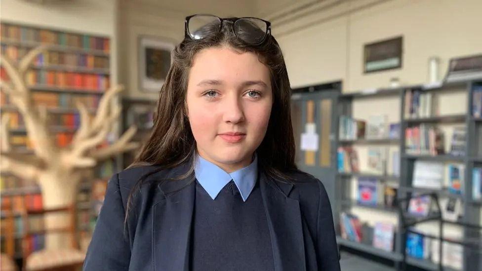 Phoebe, menina britânica em biblioteca