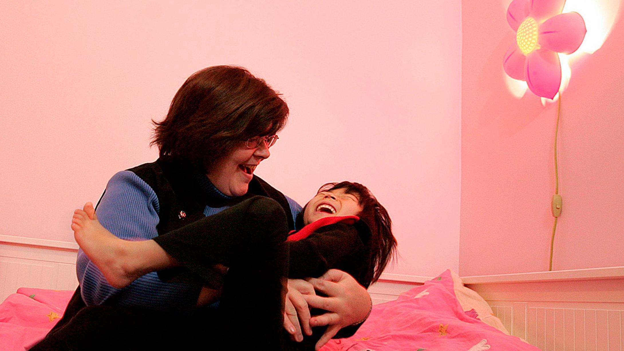 Anne Marie Devine plays with her four-year-old adopted daughter Julia, in her room