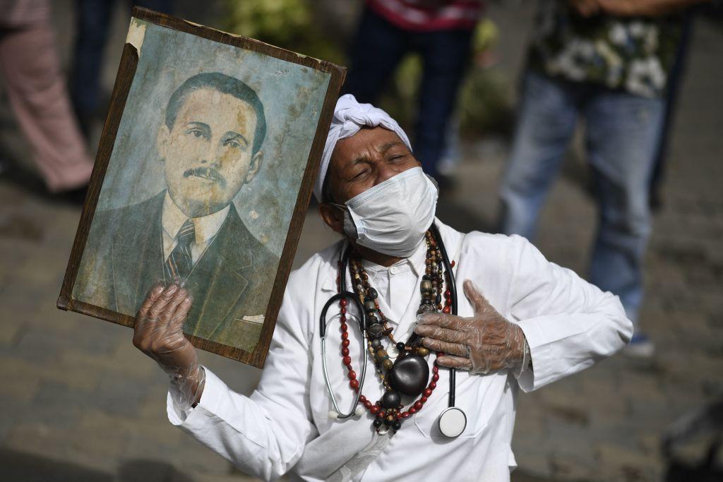 Santero con un cuadro de José Gregorio Hernández