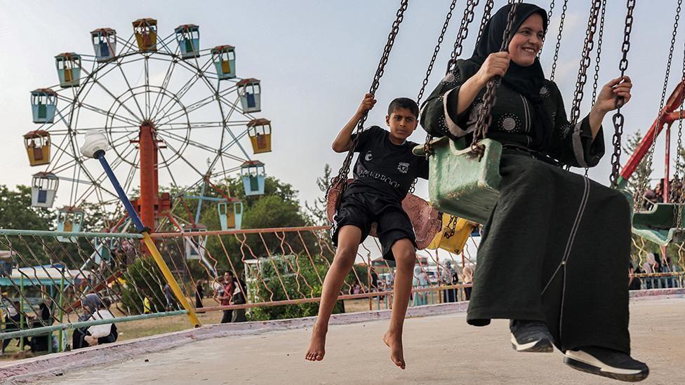 Criança e mulher em passeio no parque de diversões