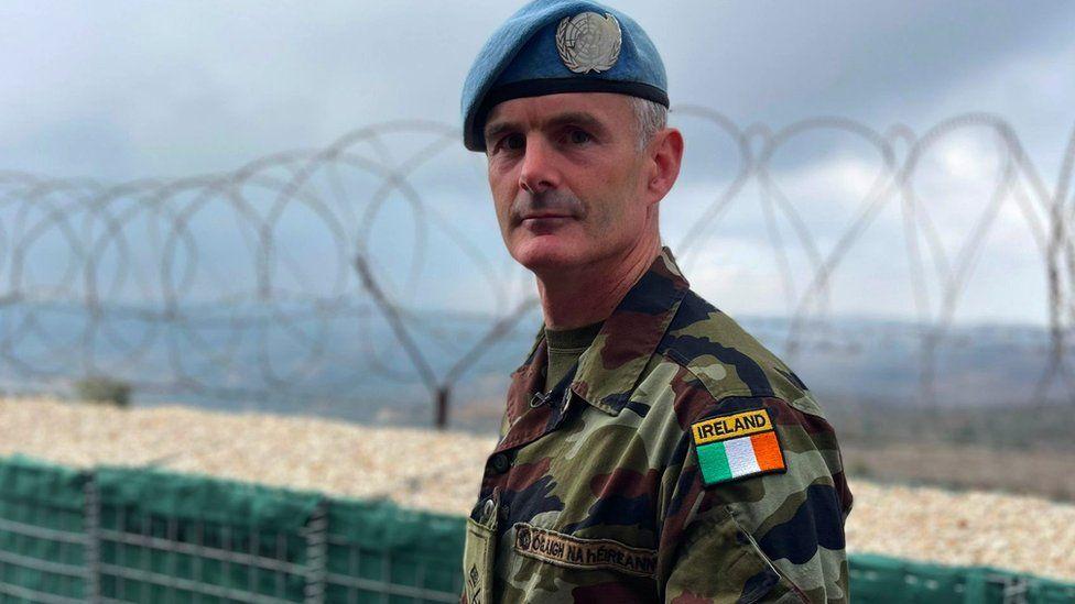 Lieutenant Colonel Cathal Keohane stood in front of a barbed wire fence