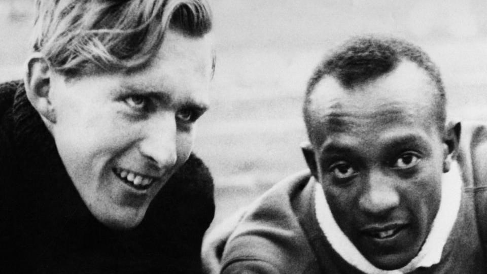 Luz Long (kiri) dan Jesse Owens menciptakan momen ikonik pada Olimpiade Berlin 1936.