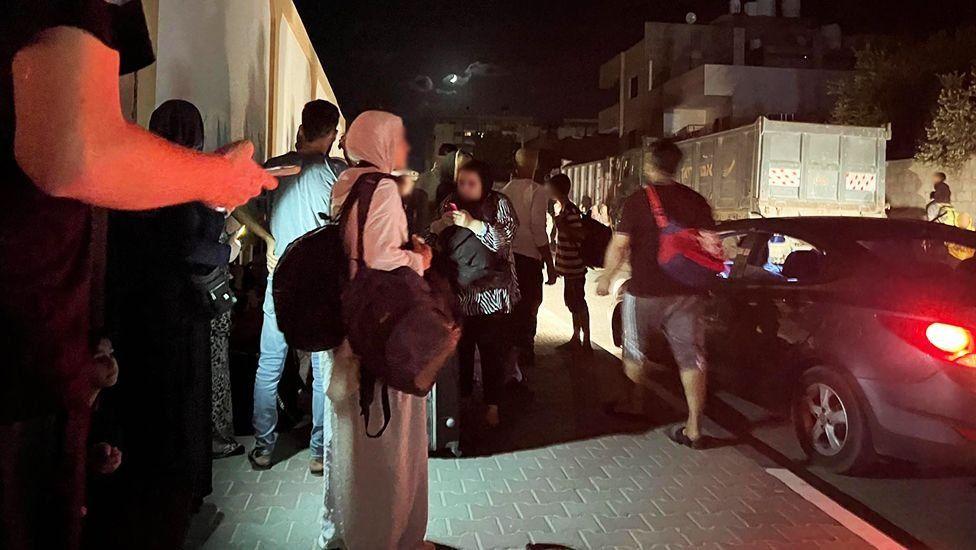 Pessoas esperando nas ruas de Al-Zahra à noite