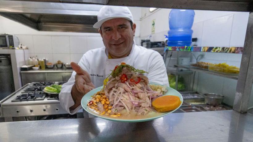 Un cocinero muestra un plato de cebiche.