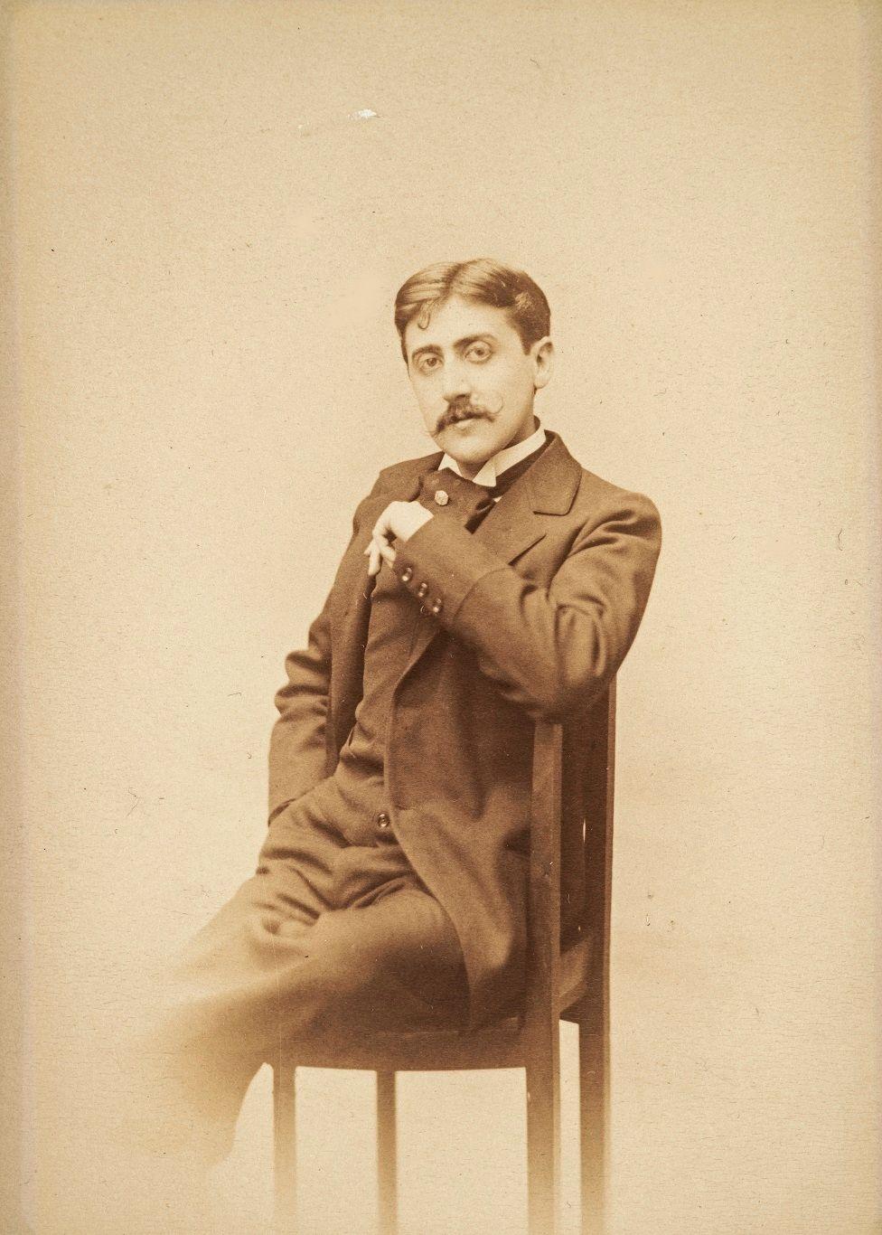 Marcel Proust, com olhar penetrante, sentado em uma cadeira