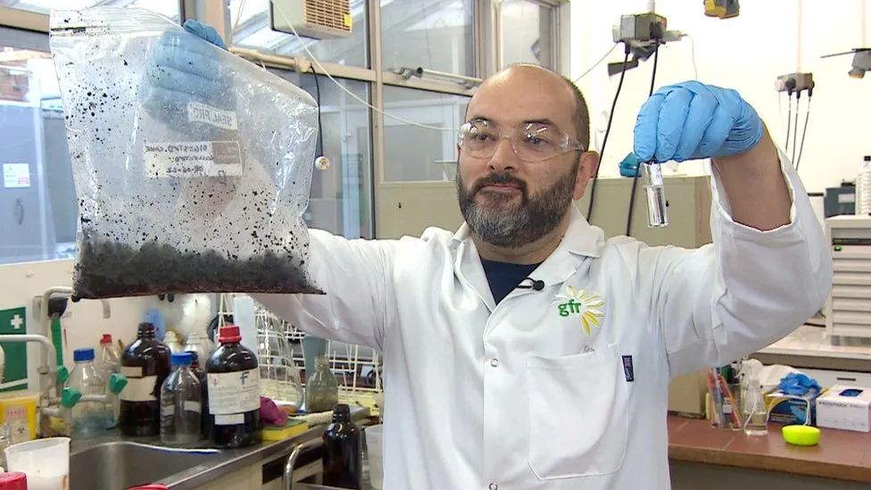 Português Sergio Lima em seu laboratório exibindo sua invenção de querosene produzido a partir de fezes humanas