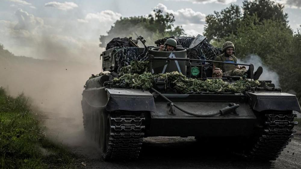 Dos soldados ucranianos se sientan en lo alto de un tanque en la región de Sumy.