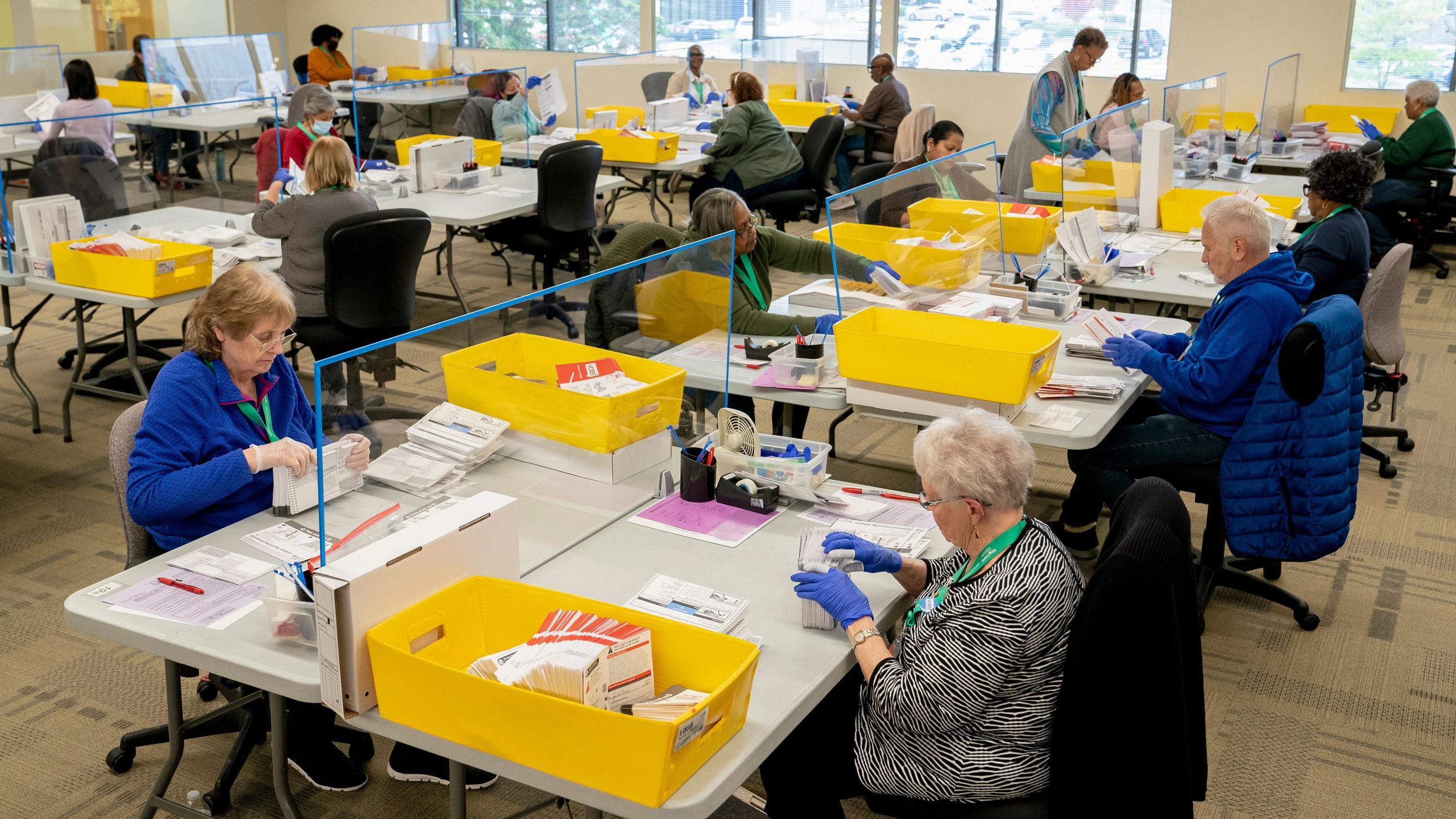 Funcionários eleitorais organizam a contagem dos votos na sede eleitoral do condado de King, em Renton, Washington, EUA.