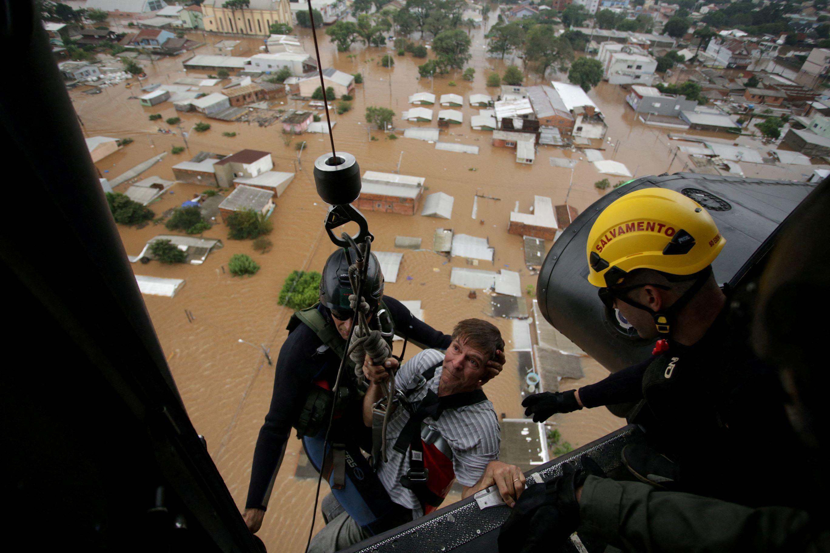 Homem sendo resgatado de helicóptero