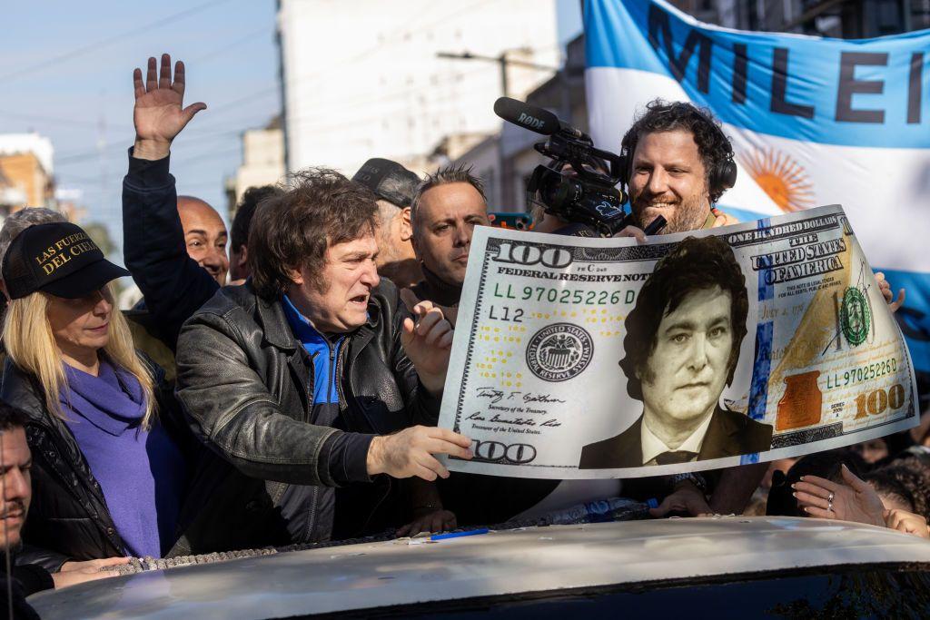 Javier Milei en campaña con una pancarta de dólar con su imagen