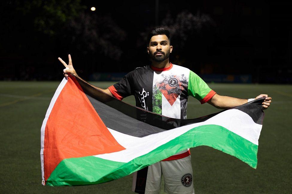 Khaled Dader con la bandera palestina en una cancha