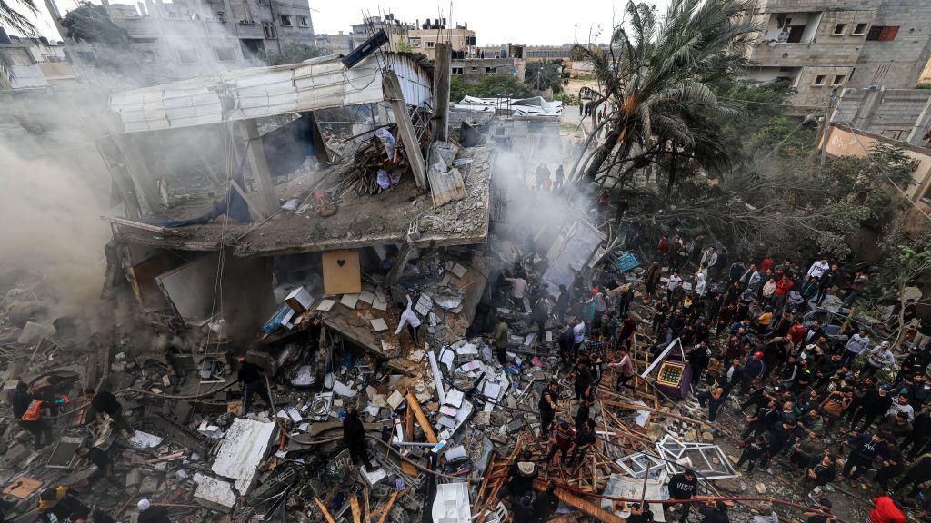 Warga Palestina berkumpul di sekitar rumah keluarga Shehada yang hancur menyusul pemboman Israel terhadap Rafah di Jalur Gaza selatan pada 14 Desember 2023.