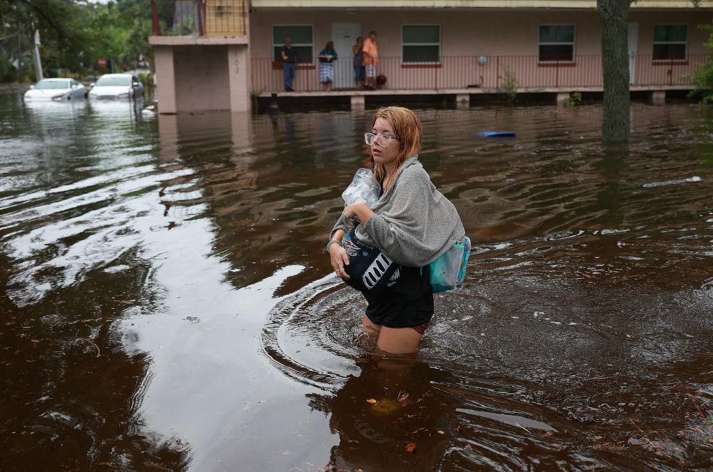 Makayla Richter atraviesa las aguas de la inundación después de tener que evacuar su casa en Tarpon Springs, Florida.