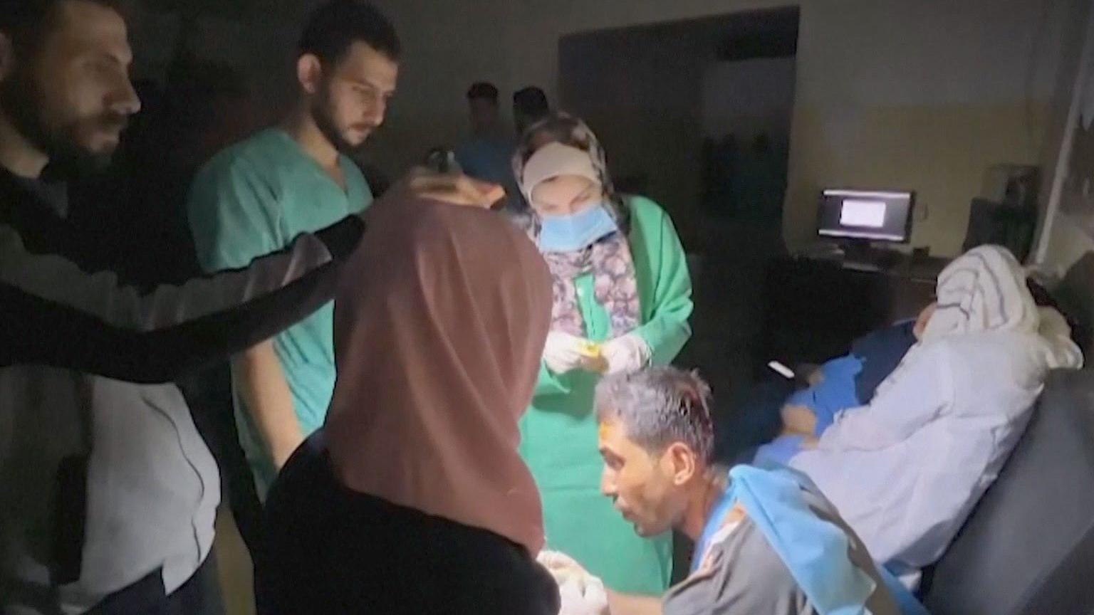 أطباء في مستشفى الشفاء يجرون عمليات جراحية على أضواء مصابيح يدوية يدوية