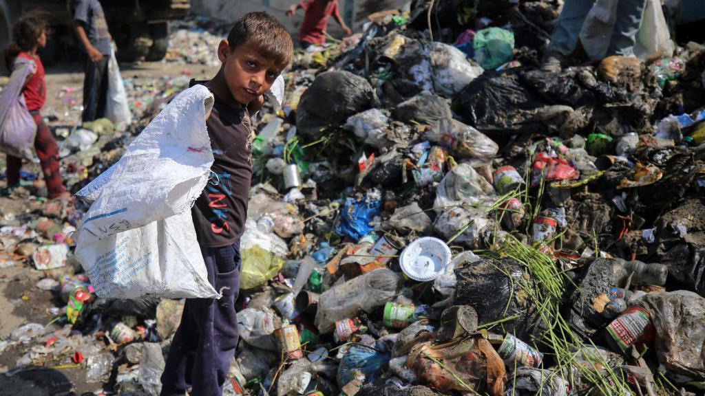Un niño en una montaña de basura.