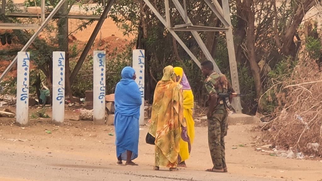 مجموعة من النساء يتحدثن مع عسكري